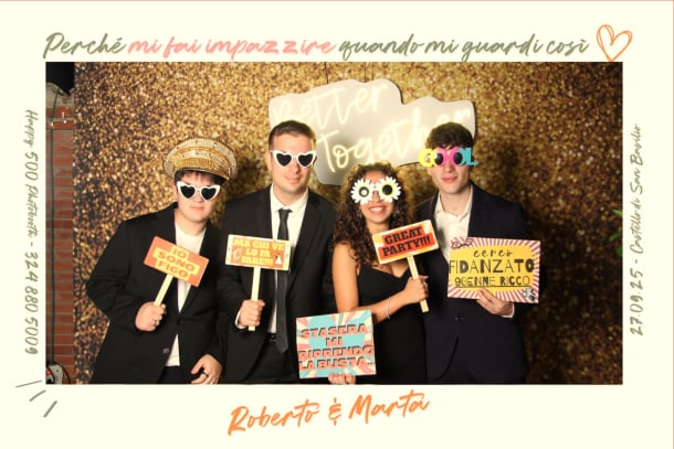 Primo piano di sposi divertiti mentre indossano gadget e accessori vintage al photobooth.